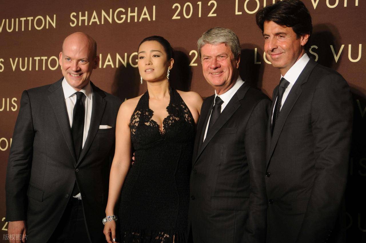 巩俐陪马克龙夫妇吃烤鸭，穿黑衣扎丸子头气场强，快六十岁还很美