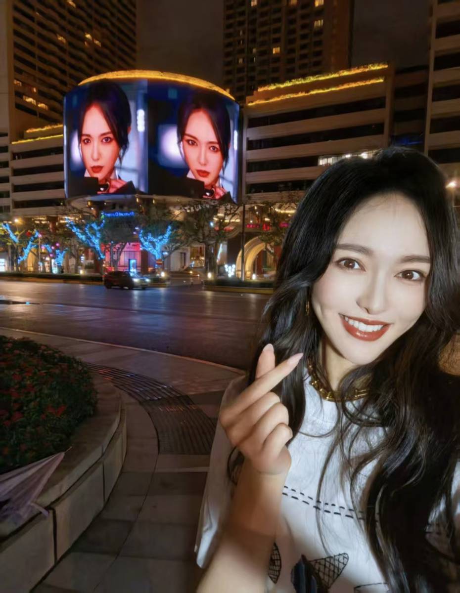 唐嫣夜晚街头打卡自己大屏 穿搭松弛笑容好明媚
