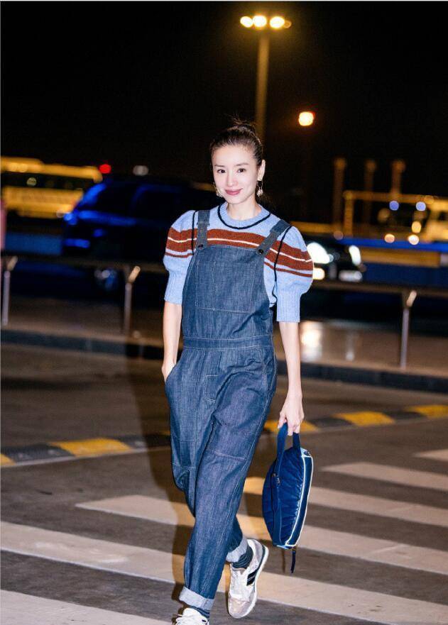 39岁的董洁在机场街拍中身穿一条牛仔背带裤,再次提升了背带裤的