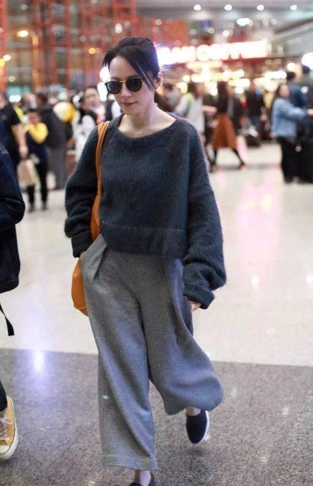 走机场时,俞飞鸿选择了黑色毛绒毛衣搭配灰色休闲裤,展现了休闲舒适的