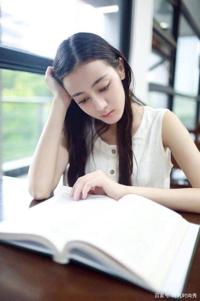 的迪丽热巴只有15岁,穿着一件棕色上衣搭配黑色裤子,扎着一个丸子头