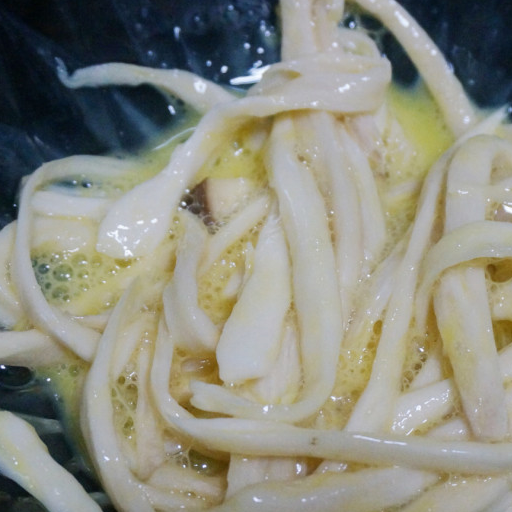 第7步,锅中放入足够的油,中小火,油6成热,放入裹上糊的杏鲍菇丝,一定