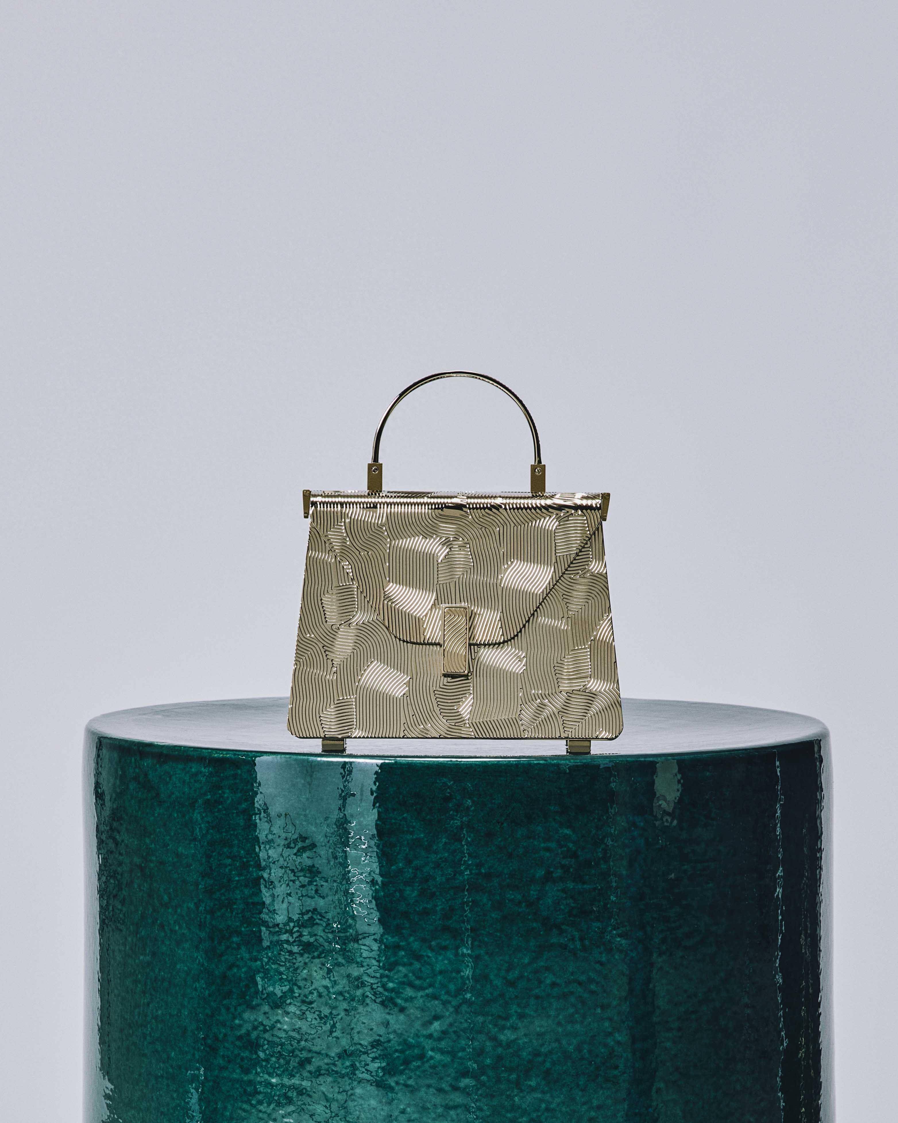 iside minaudiere手袋经过精心设计,轻巧便携,包身表面的波浪状图案由