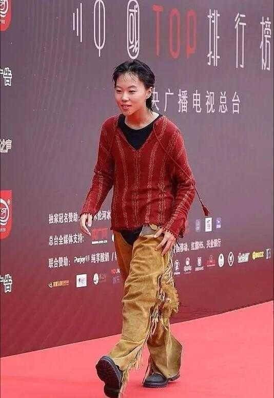 宽松的红色针织衫上面融入了竖条纹的纹路,而且领口结合了v领的设计