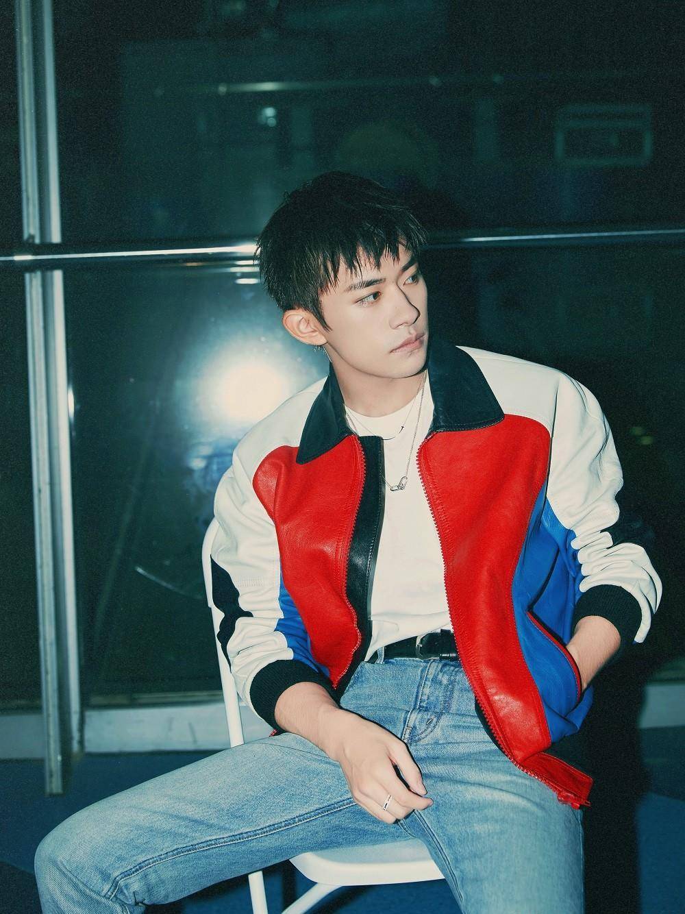 易烊千玺在唱着《1起挺你》,身着红蓝白色外套,经典又时尚,类似奥特曼