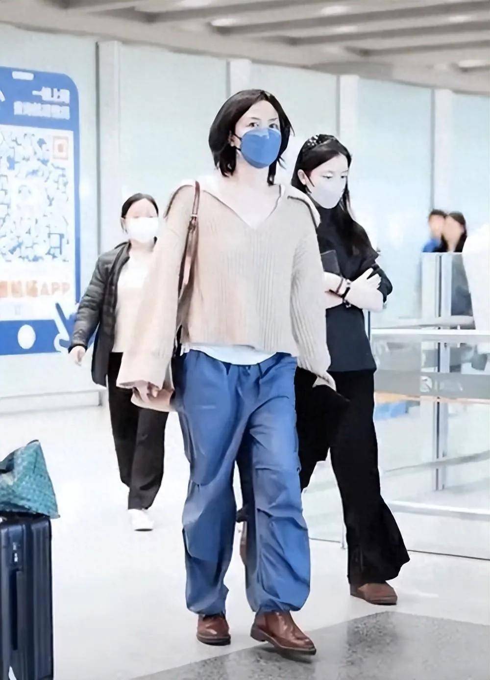 王菲一身浅棕色针织开衫搭配蓝色牛仔裤,简单而不失优雅,口罩下难掩她