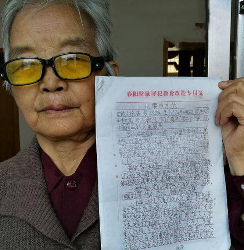 徐母赵克凤拿着儿子的申诉状而这起案件受到伤害的除了"凶手"徐浩外