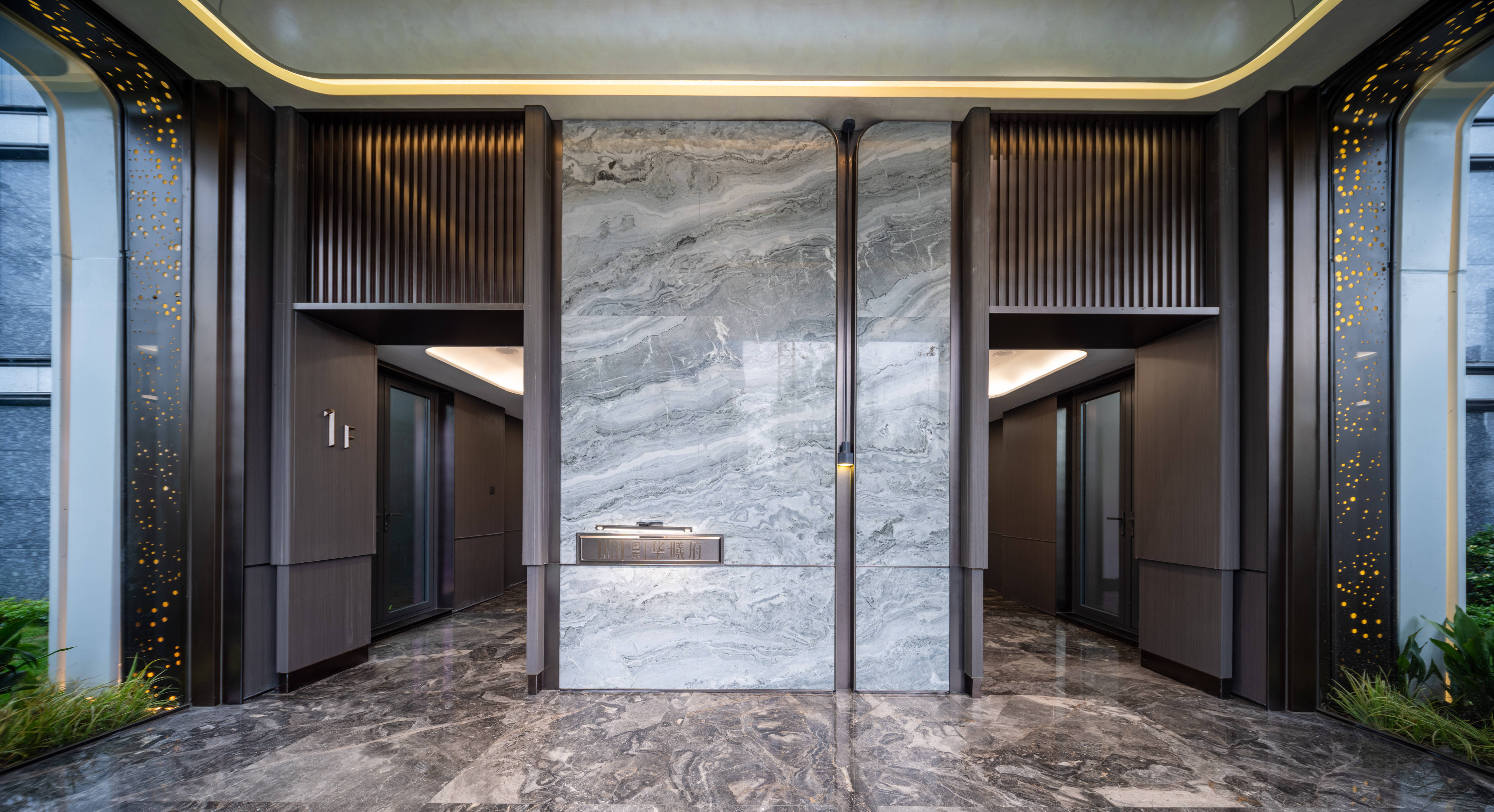 全透明玻璃入户,内透出建筑外观高山流水元素的天然石材背景墙,地面