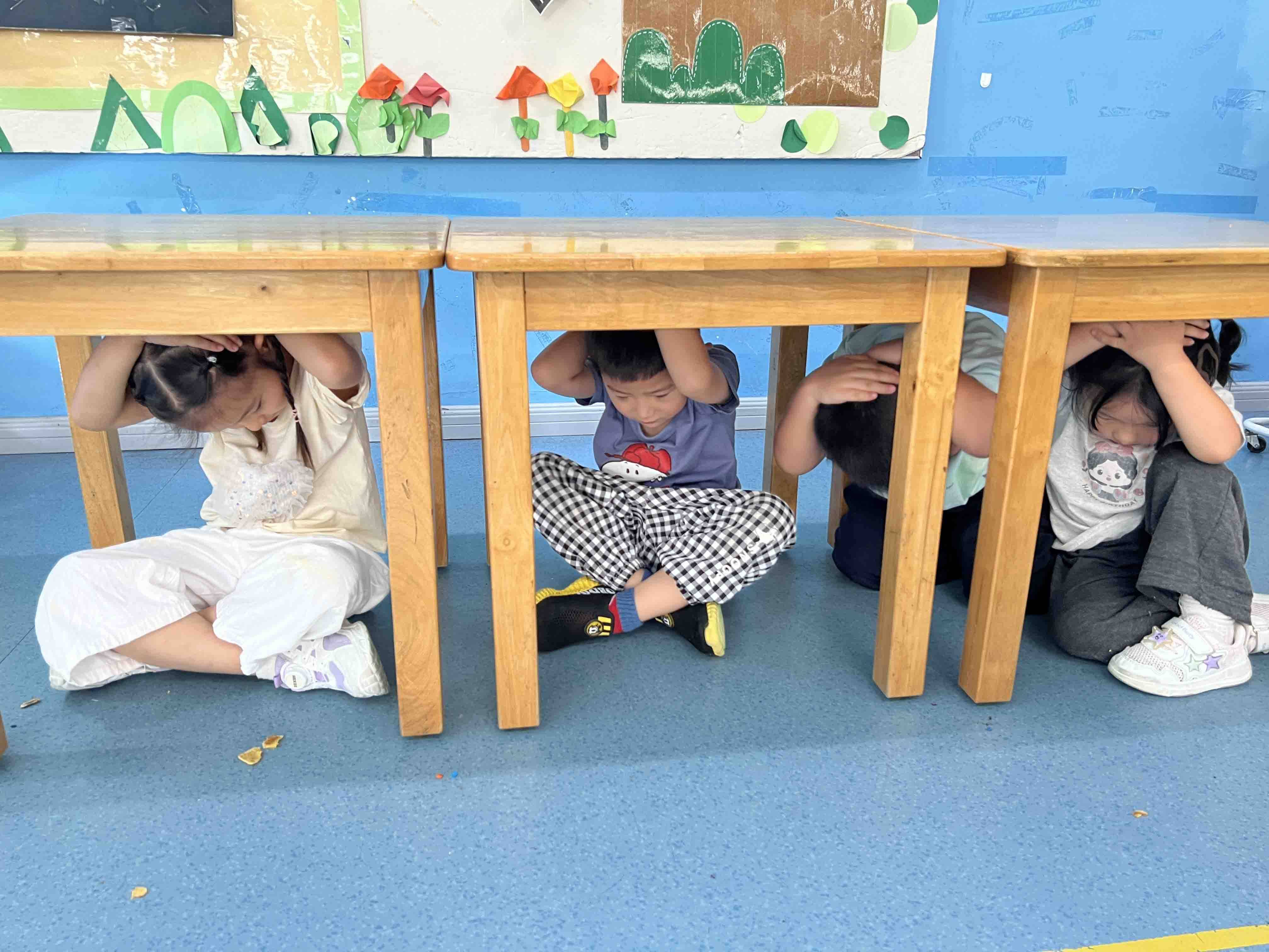 教师们还对演练过程进行简单复盘,纠正幼儿不当动作,加深孩子们对防震