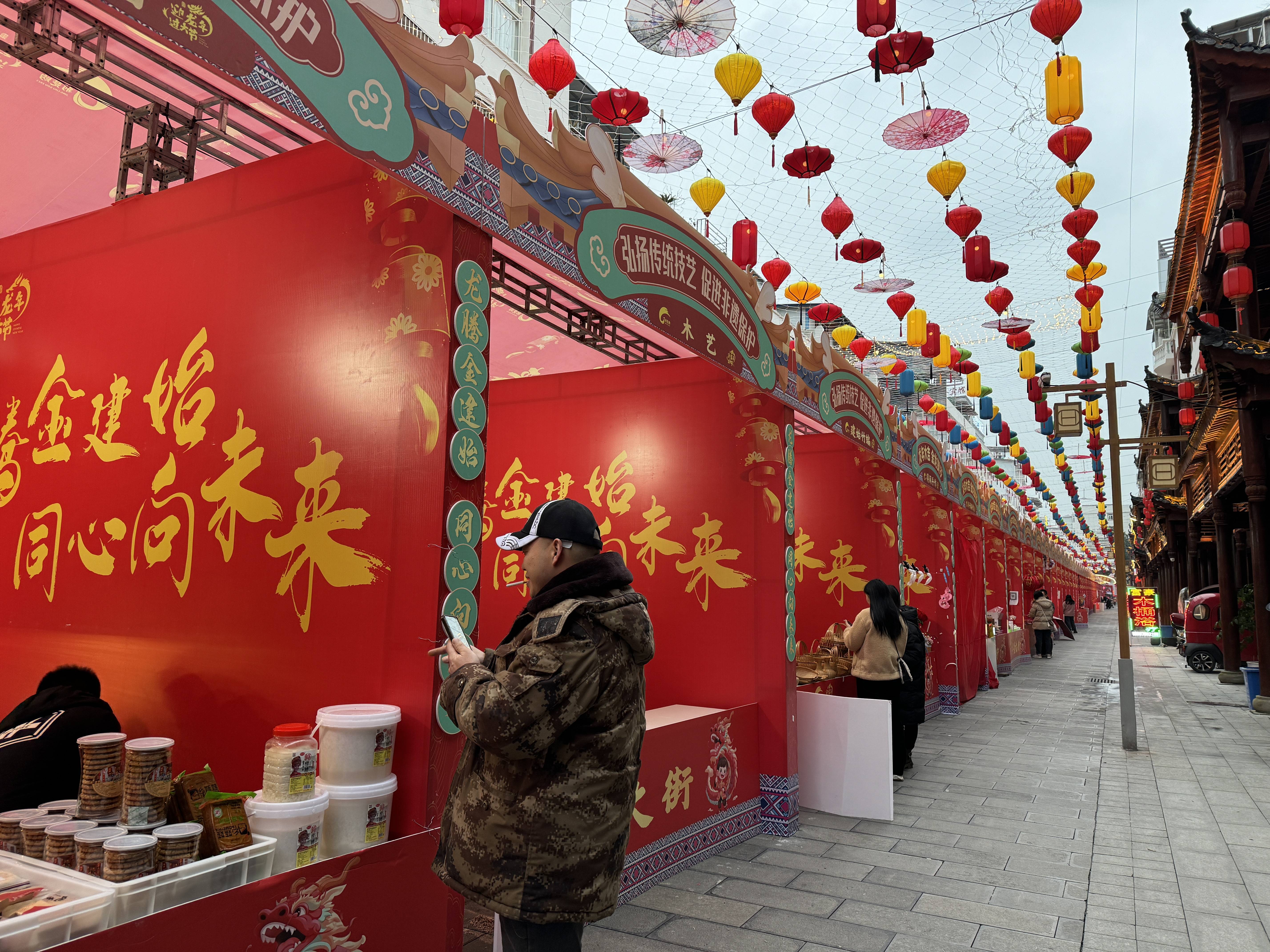 灯笼高挂,流光溢彩,虽然已是傍晚时分,年货街上的市民游客还是络绎不