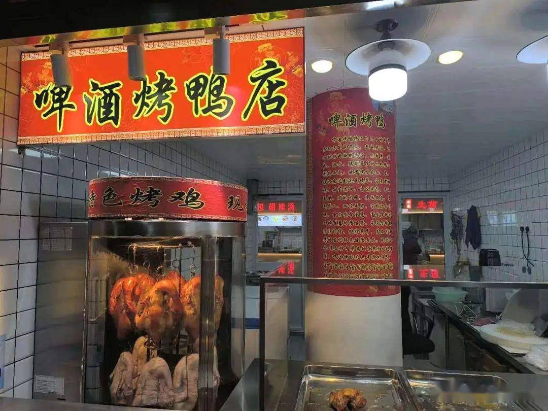 沿街面的商铺里,人气美食熏鱼坊,啤酒烤鸭的门口总有人在排队等待,要