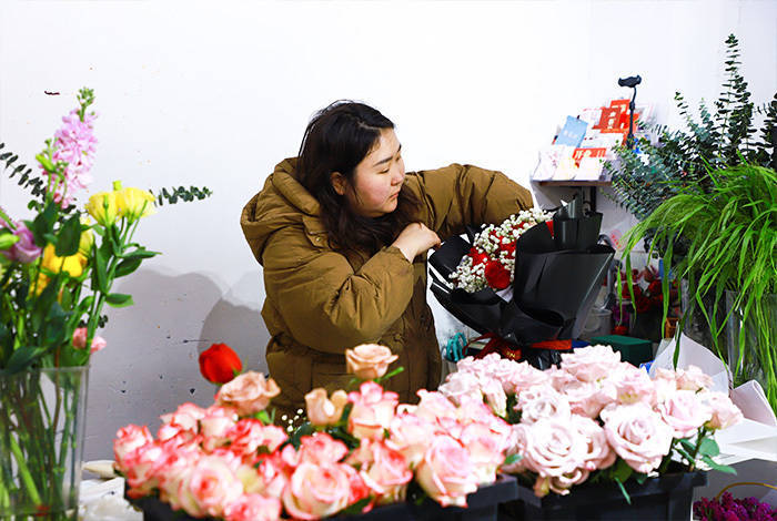 花店店主包扎鲜花"正值龙年春节,又逢情人佳节,买束鲜花送给妻子,给