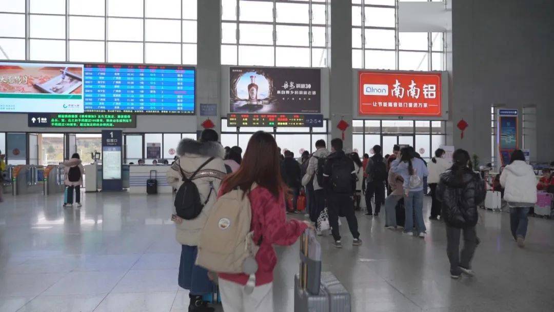 梧州南站候车厅看到,前来搭乘动车的旅客拖着大包小包有序安检进站