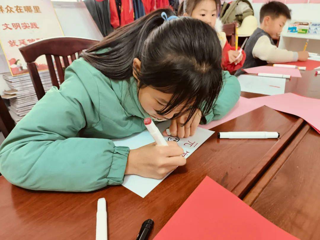 志愿者带领着孩子们了解元宵节的来源和习俗,制作有关元宵节的手抄报