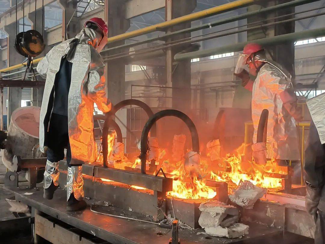 在国鑫铝业公司铝合金铸棒铸造现场,操作人员正在使用特制大铁勺将680