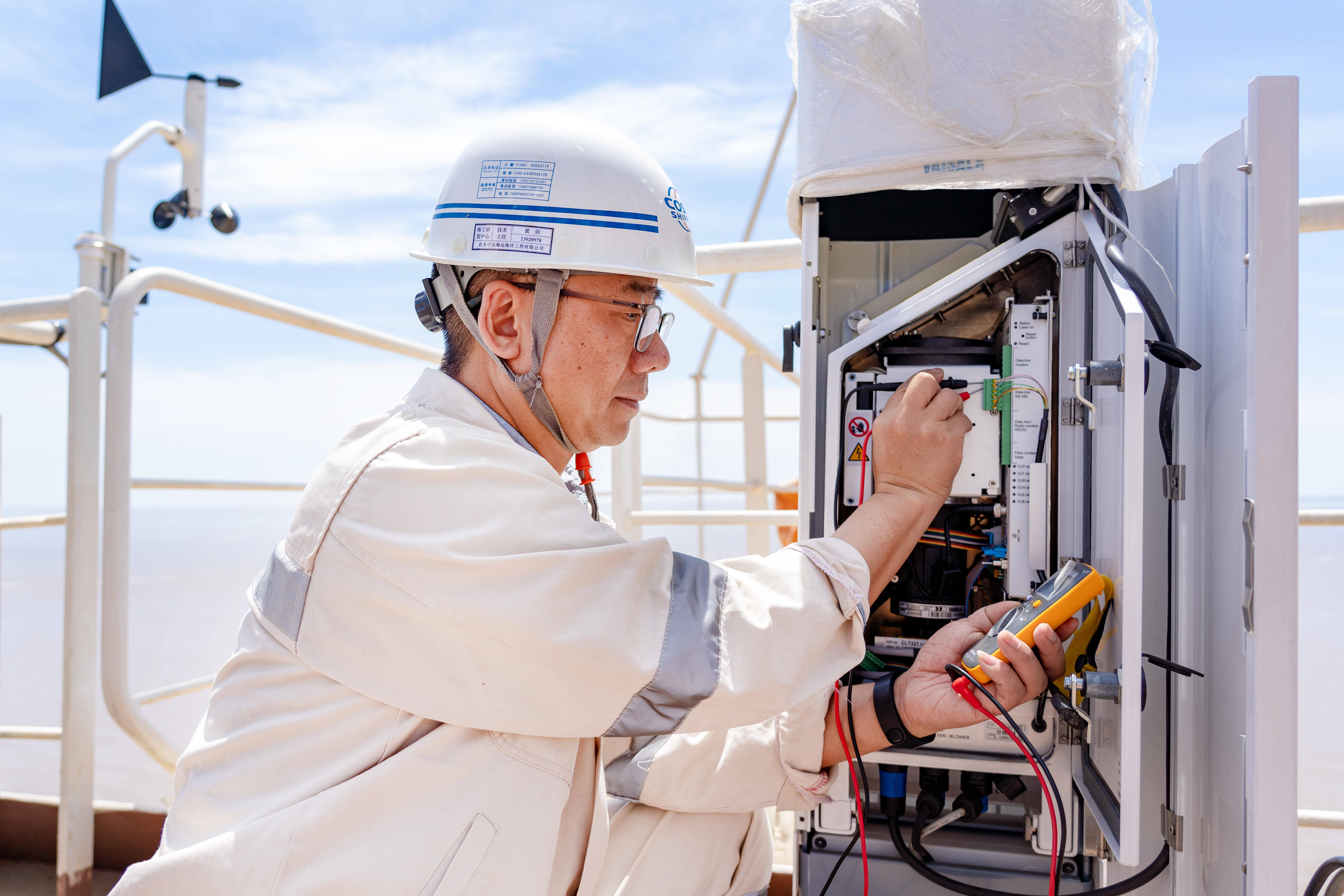 一手拿着图纸,一手握着电表,启东中远海运海洋工程有限公司海工与新