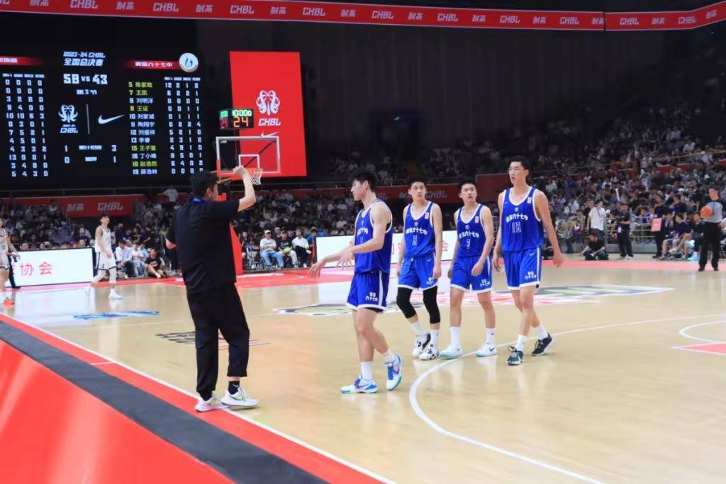 "在体育馆观看比赛的学校篮球队队员何俊毅不断地为屏幕里的队友欢呼