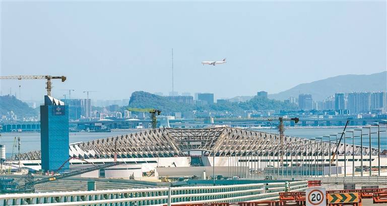 中通道向东眺望西人工岛,一架客机正从空中缓缓降落深圳宝安国际机场