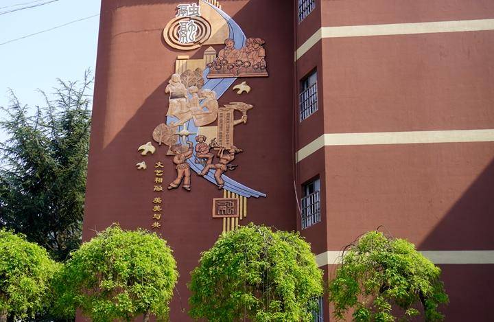 在赫章县实验中学的教学楼上,盈秋褐的外墙注入了"融"文化的图案,学生