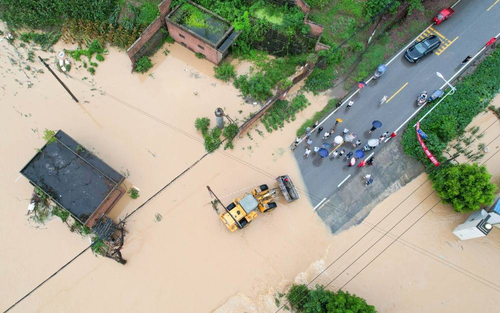 7月11日上午,垫江县澄溪镇,当地政府组织铲车转移受灾群众