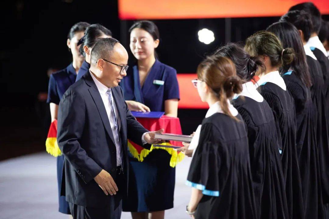 "开学典礼现场,深技大党委书记张基宏为优秀新生颁发新生奖学金,希望