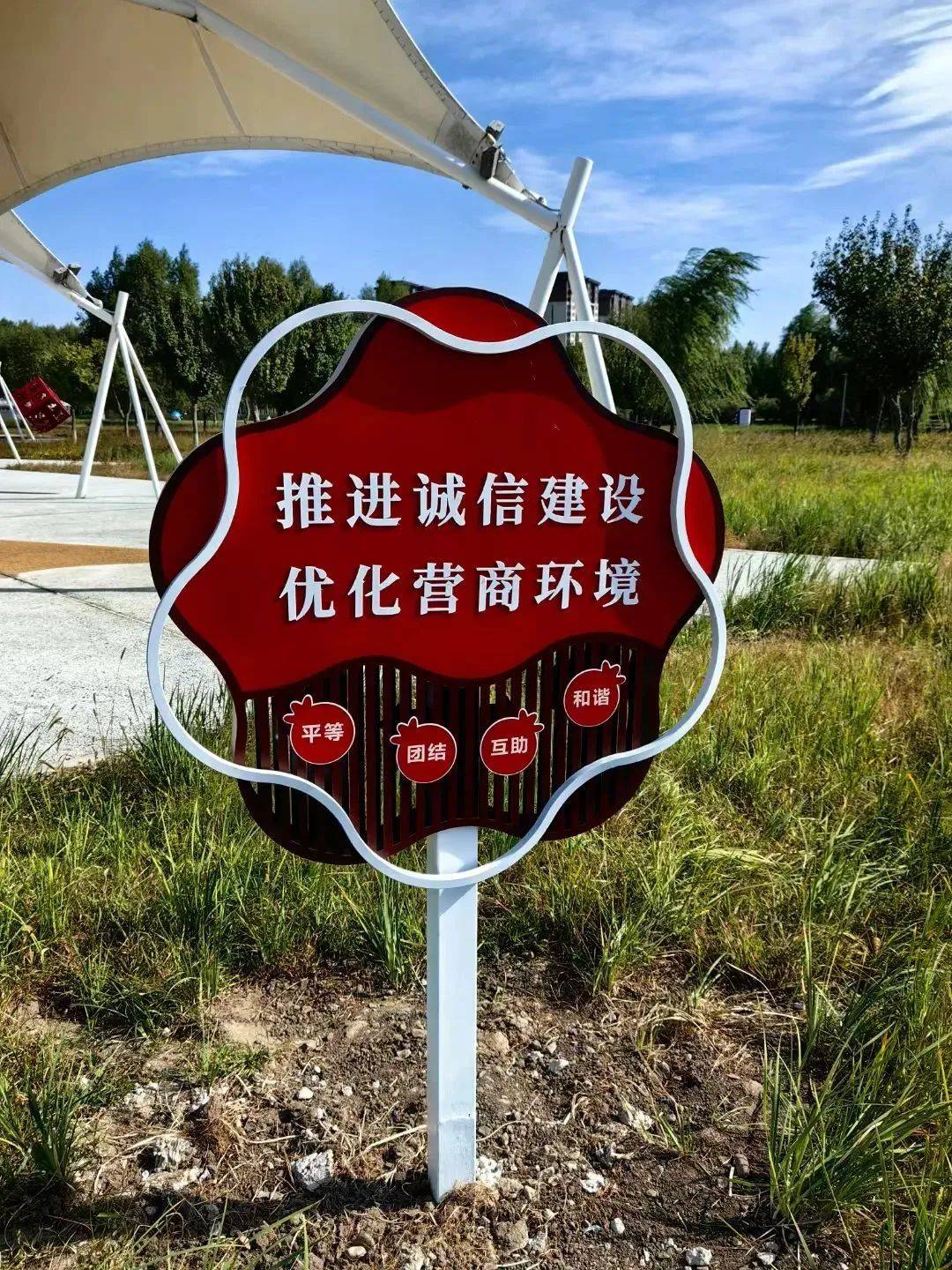 现代艺术字,体现着"推进诚信建设 优化营商环境"的援助标语以及代表着