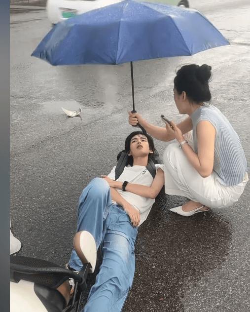 安徽热心女子给被撞倒男孩撑伞，网友却被男孩颜值惊呆！网友：帅得出事了还以为在摆拍
